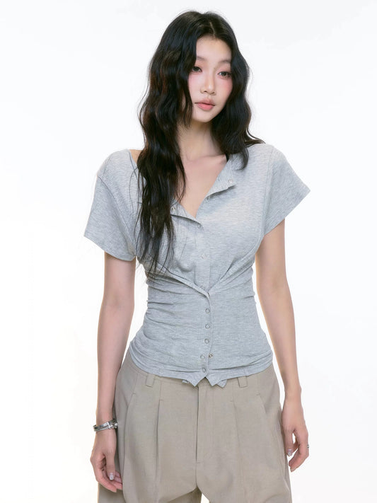 Woman wearing a gray short-sleeve top and beige pants on a white background