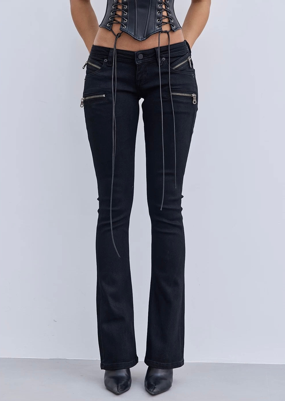 Black flared jeans with zippers on a white background