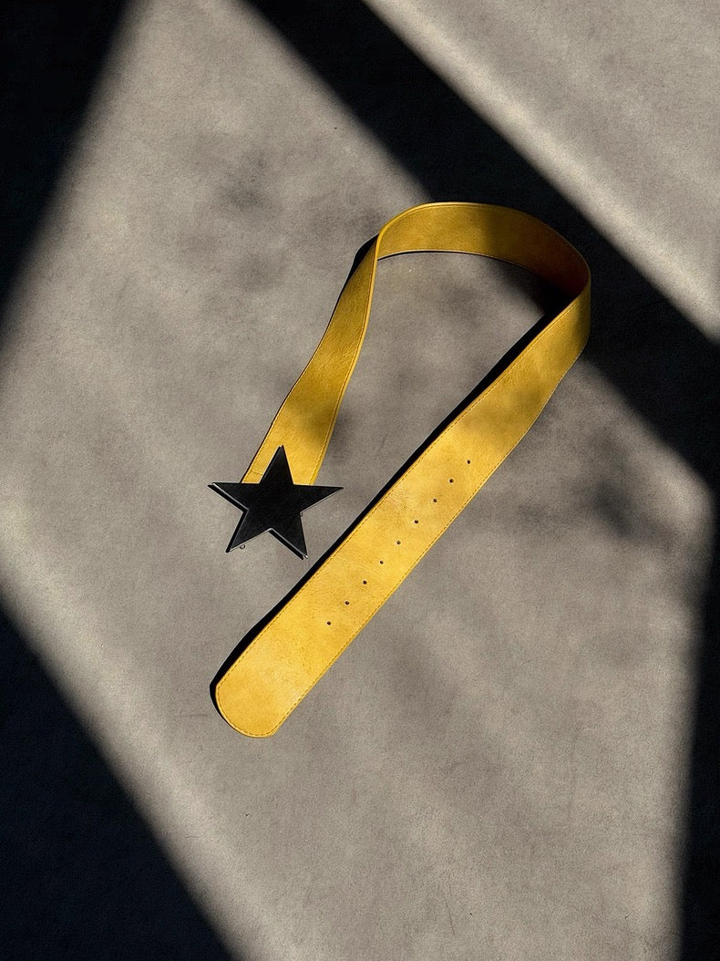 Gold belt with a black star on a gray background