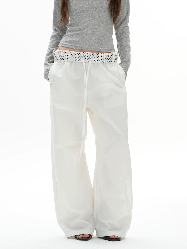 White wide-leg pants with a patterned waistband worn by a person on a white background