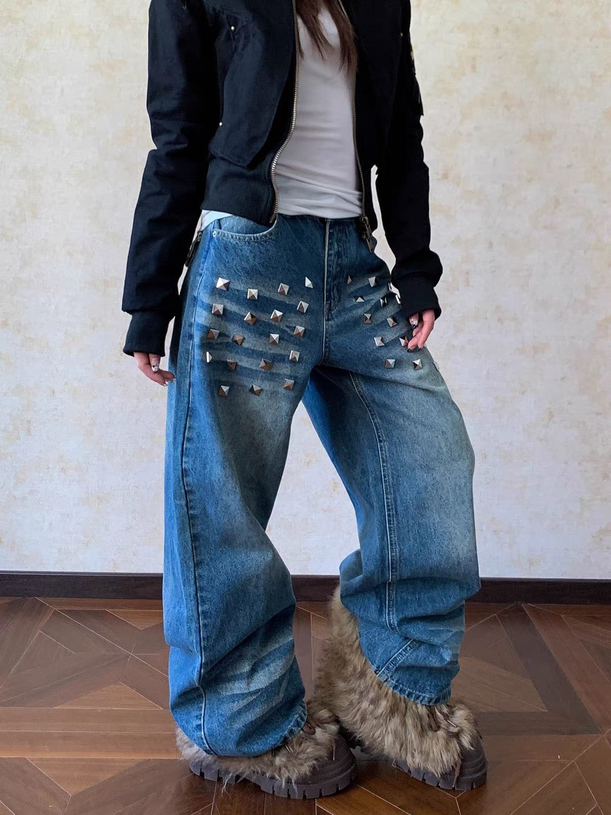 Person wearing studded blue jeans and furry boots indoors.