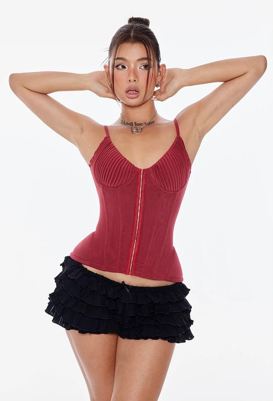 Woman wearing a red corset top and black skirt on a white background