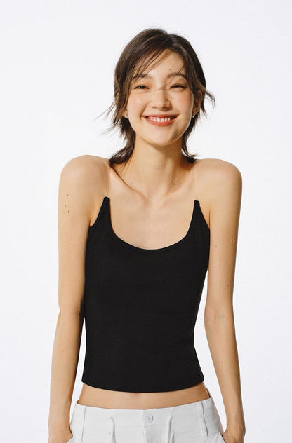 Woman wearing a black tank top against a white background