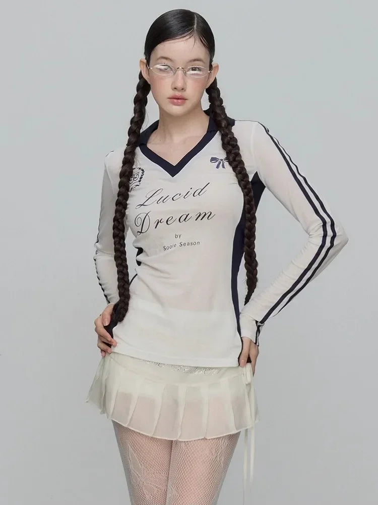 woman wearing a white mesh long sleeve with silver glasses and a white mini skirt.