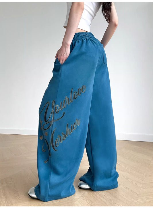 Person wearing blue sweatpants with text on a plain background